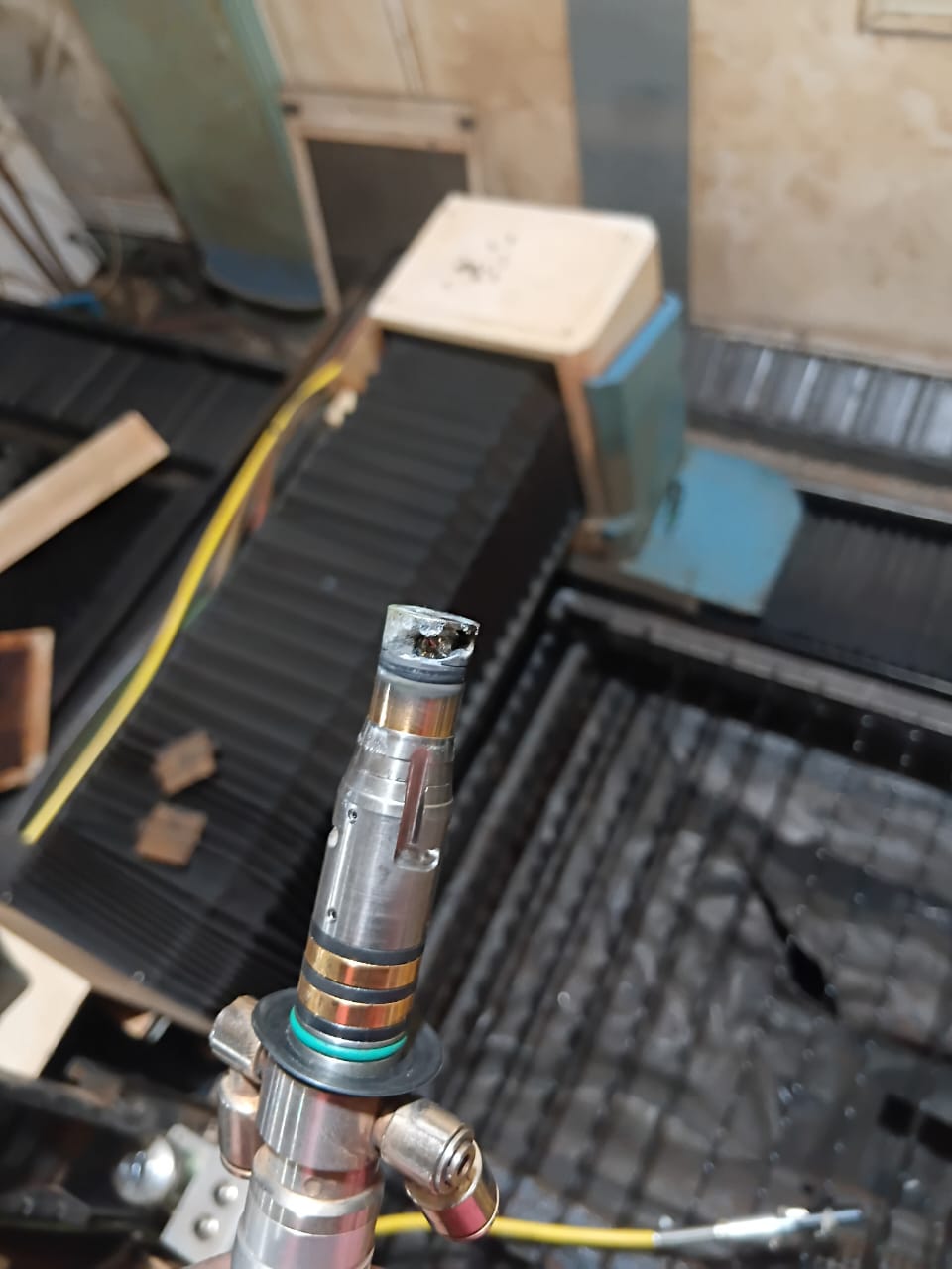 Beschädigte Düsenaufnahme eines Faserlaser-Schneidkopfs mit Brandspuren