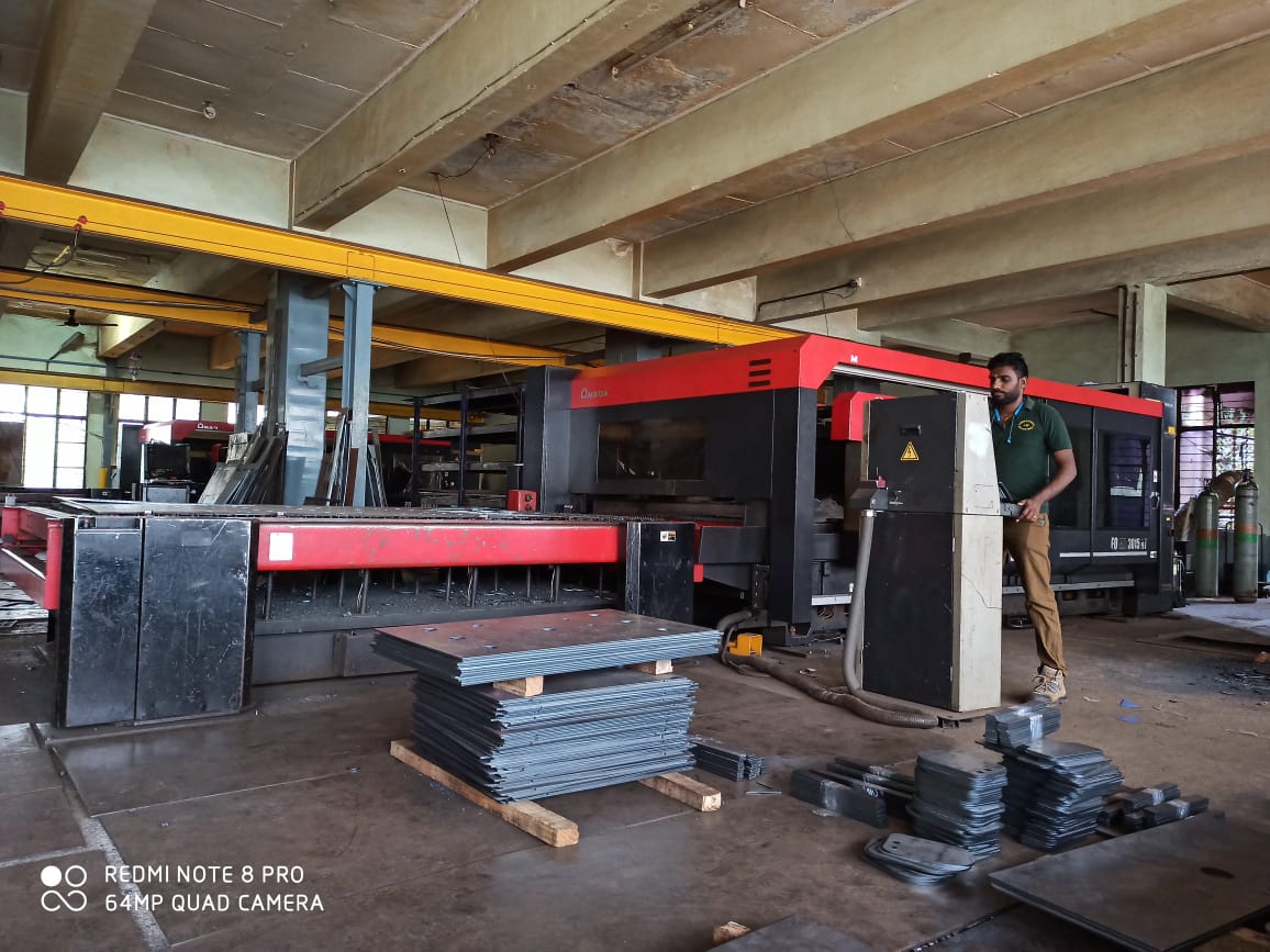 Techniker an einer AMADA FO 3015 NT CO2-Laserschneidanlage in einer Fertigungshalle