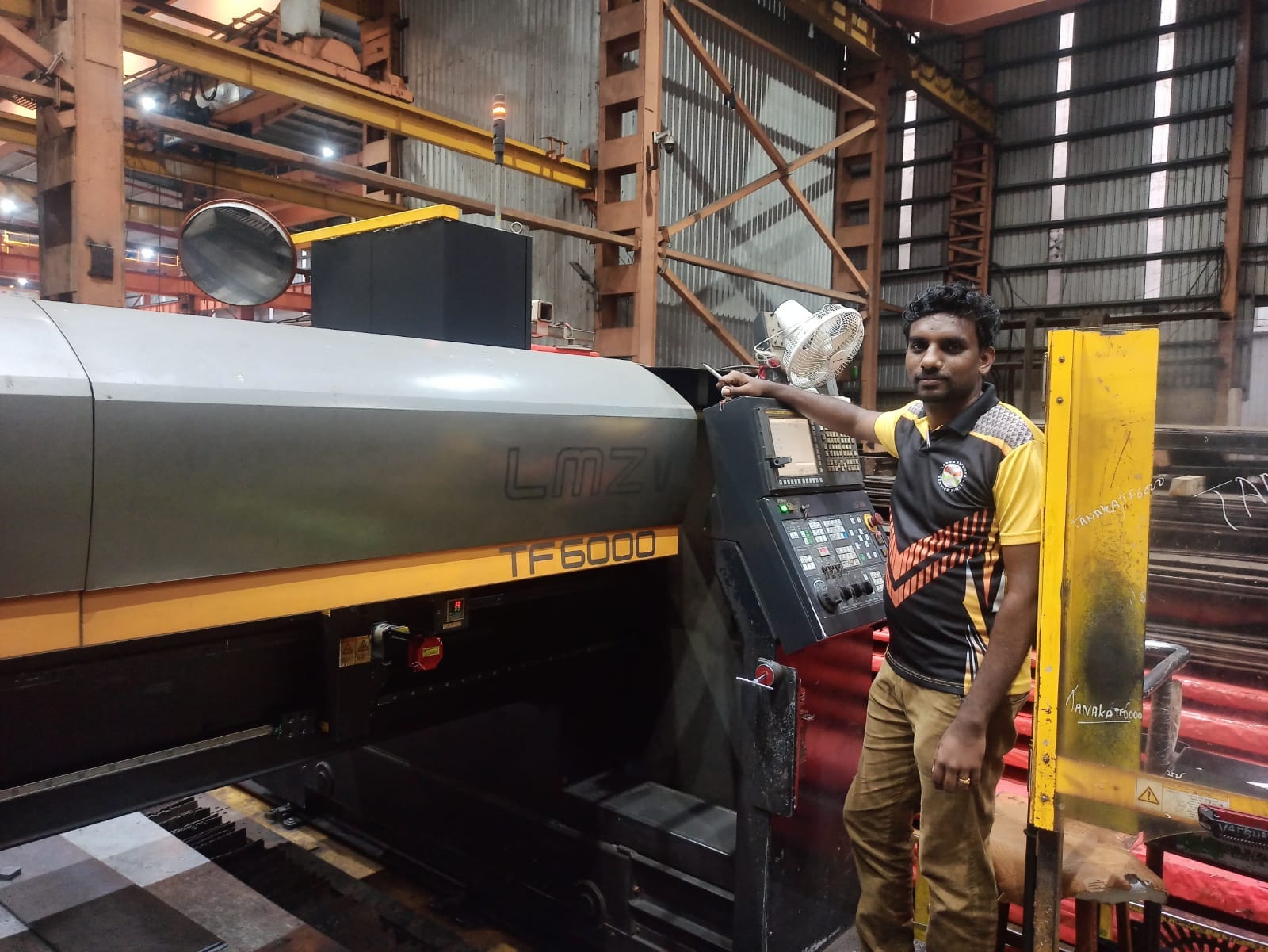 Engineer checking a laser cutting machine at its control panel