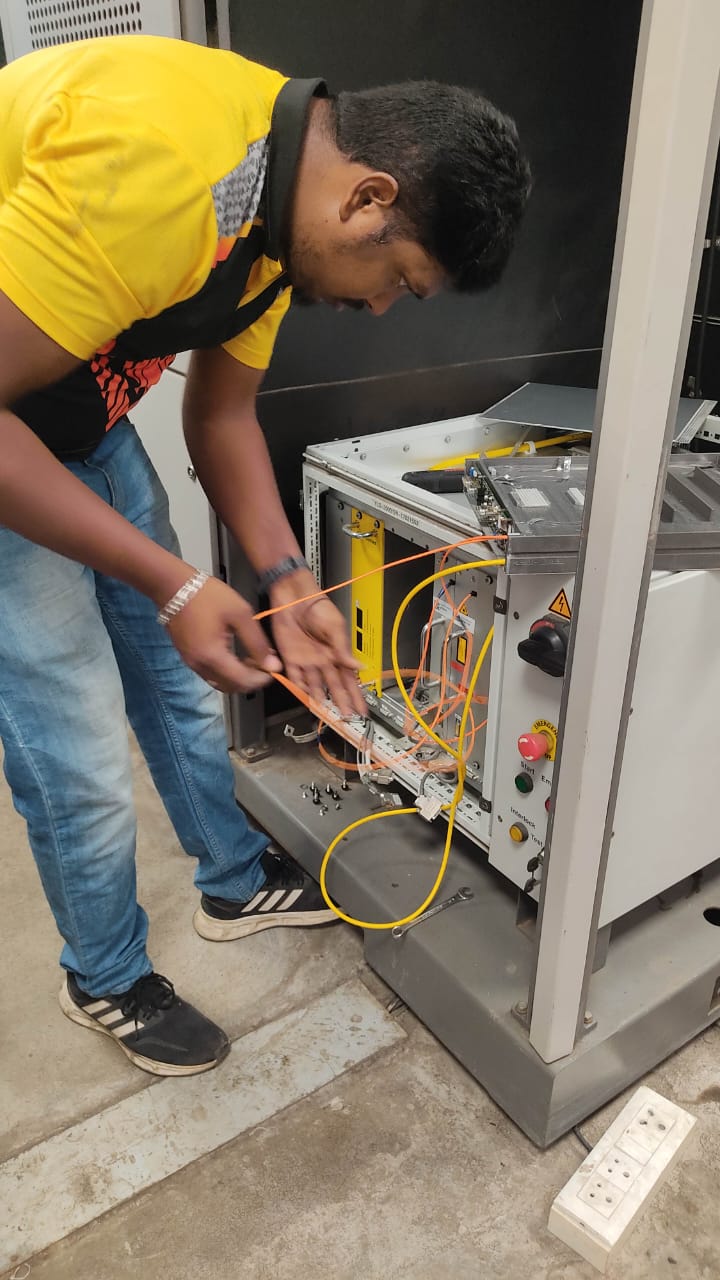 Techniker arbeitet an den Modulen im geöffneten Schrank einer Faserlaserquelle