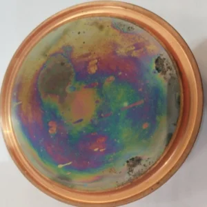 Adaptive copper mirror with coloured oxidation and dark deposits on the mirror surface